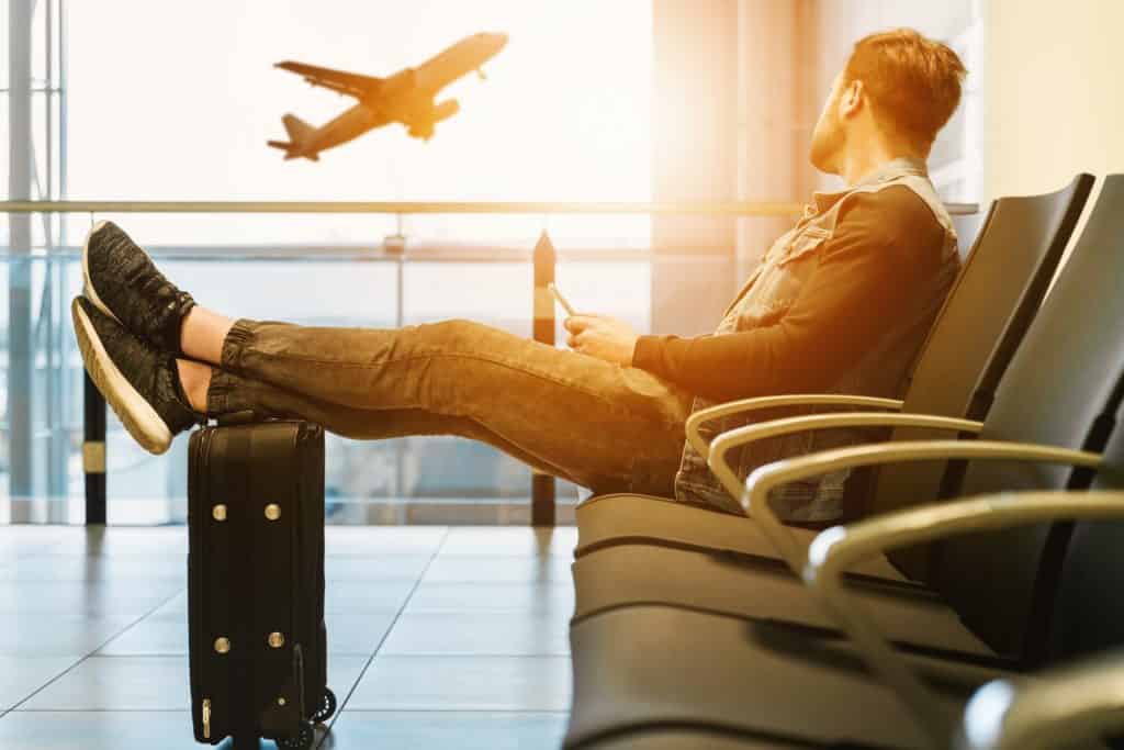 Man at airport looking at plane taking off